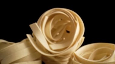 İtalyan tagliatelle makarna rulolarının makro videosunu büyüt. 8K 'da kırmızı helyum kamerayla çekildi.