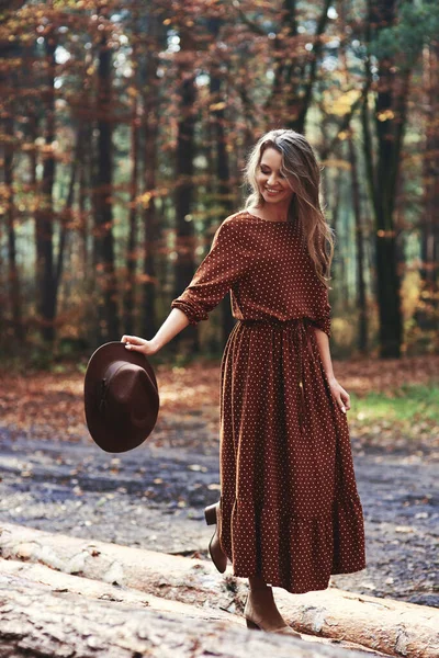 女性は手で彼女の帽子と森の中を歩く — ストック写真