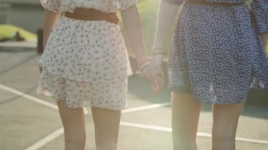 Tanımlanamayan iki kadının el ele tutuşup yürüdüğü el kameraları. 8K 'da kırmızı helyum kamerayla çekildi..