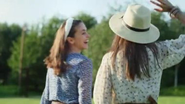 Dışarıda zıplayan ve gülen iki mutlu arkadaşın videosu. 8K 'da kırmızı helyum kamerayla çekildi.. 