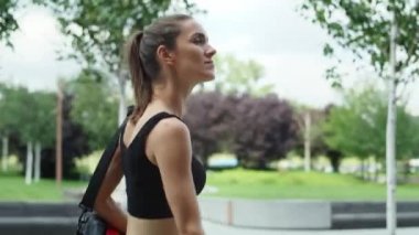 Antrenman kıyafetiyle yürüyen kadın videosu. 8K 'da kırmızı helyum kamerayla çekildi.. 
