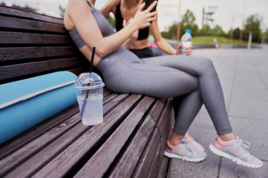 İzotonik içeceğe ve arka plandaki kadınlara yakın durun.                               