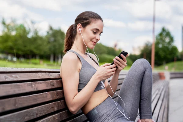 Atletická Žena Sedí Poslouchá Hudbu Telefonu — Stock fotografie