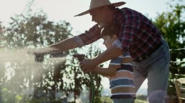 Torunumun büyükbabamla bahçede sebze sularken videosu. 8K 'da kırmızı helyum kamerayla çekildi..