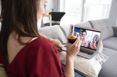 Doğumgününü video konferansında kutlayan bir kadının arka görüntüsü                               