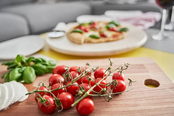 背景中的樱桃西红柿和披萨的特写 — 图库照片