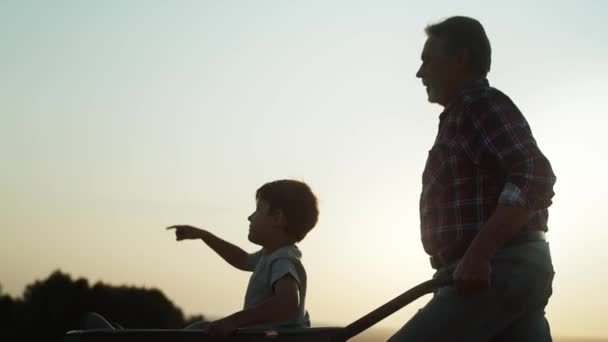 Video Del Abuelo Conduciendo Nieto Carretillas Atardecer Fotografía Con Cámara — Vídeo de stock