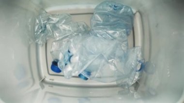 Çöp kutusuna düşen plastik şişelerin videosu. 8K 'da kırmızı helyum kamerayla çekildi.