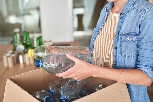 无法辨认的女人拿着塑料瓶进行回收 — 图库照片