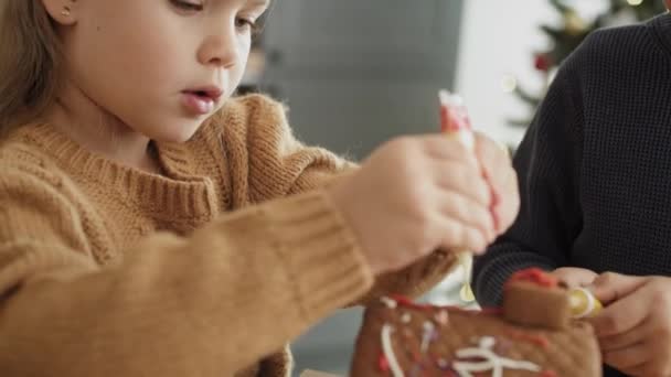 Video Little Girl Focused Decorating Gingerbread House Shot Red Helium — Stock Video