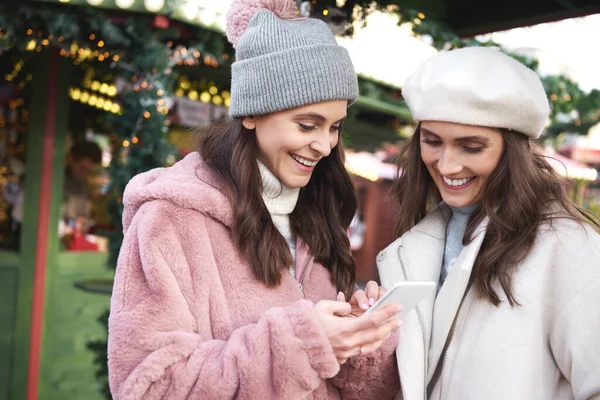 Dois Amigos Mercado Natal Navegando Telefone Celular — Fotografia de Stock