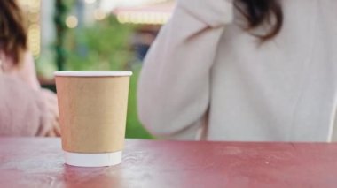 Ahşap masada kahve içen kadınların el kamerası görüntüsü. 8K 'da kırmızı helyum kamerayla çekildi..