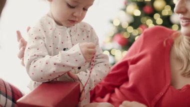 Noel sabahı hediye paketini açan küçük kızın videosu. 8K 'da kırmızı helyum kamerayla çekildi..