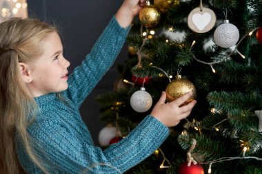 Noel ağacına süslenmiş şirin bir kız.
