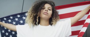 Amerikan bayrağı taşıyan genç kadının videosunu büyüt. 8K 'da kırmızı helyum kamerayla çekildi..