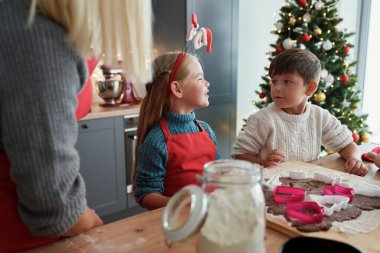 Çocuklar Noel zamanı için zencefilli kurabiye pişiriyor.