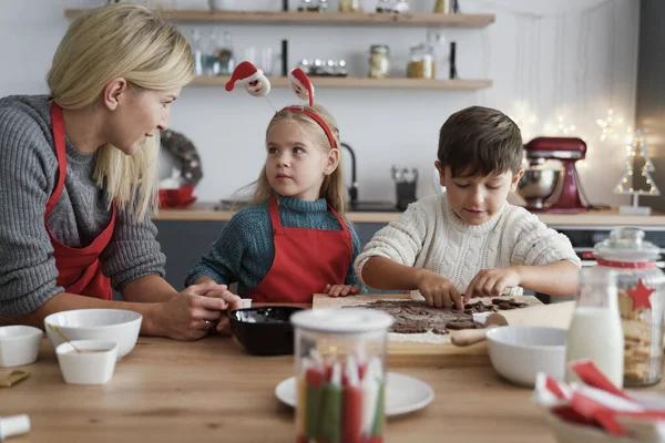 Két Gyerek Anyjuk Mézeskalács Sütit Szeletelnek — Stock Fotó