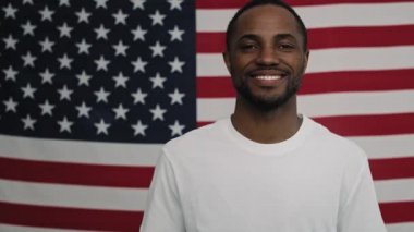 Amerikan bayrağında neşeli siyahi bir adamın videosu. 8K 'da kırmızı helyum kamerayla çekildi..