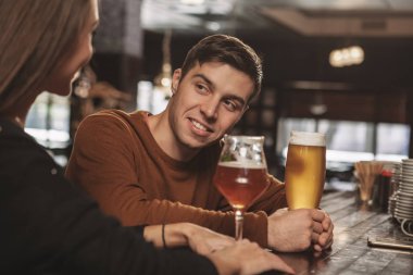 Onun kız arkadaşı birlikte barda zanaat lezzetli bira yudumlarken konuşan yakışıklı mutlu adam. Çekici bir adam olması onun kadınla flört beraber içer. Dating, romantizm, çift kavramı