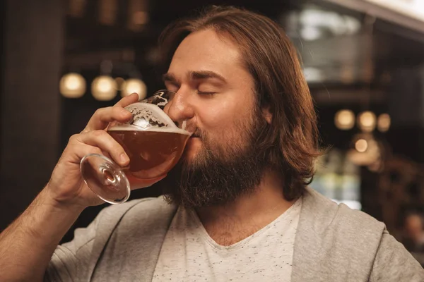 Close Jovem Barbudo Cabelos Compridos Bebendo Cerveja Alegremente Com Olhos — Fotografia de Stock