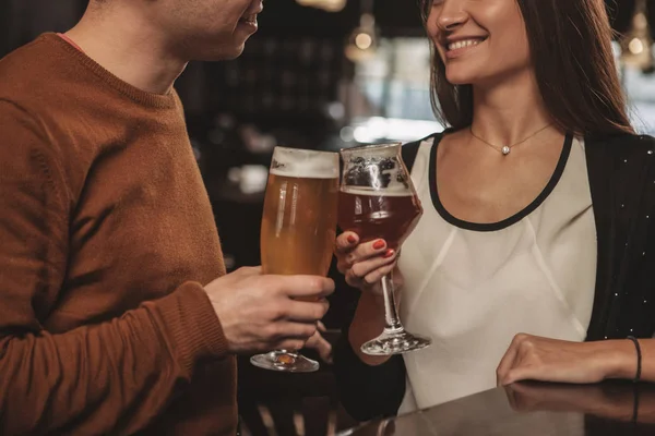 Seçici odak restoranda yılını kutlayan çift elinde tungur bira gözlük. Sevgi dolu bir çift onların bira gözlük ile toasting in atış kırpılmış. Rekreasyon, çiftler kavramı