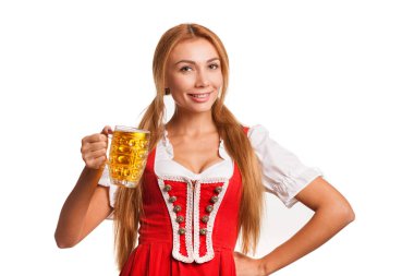 Stüdyo portre sevinçle bir kupa bira ile poz kameraya gülümseyen bir çarpıcı seksi Oktoberfest garson beyaz izole. Bavyera kız geleneksel elbise onun elinde bir bira ile kutluyor