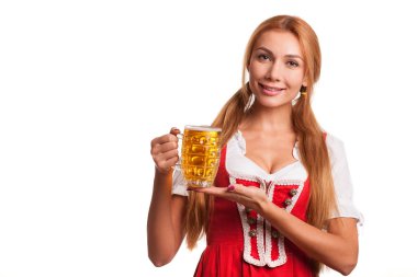 İncelikle izole onun elinde bira ile poz kameraya gülümseyen dirndl giyen genç güzel seksi Bavyera kadın. Çekici garson bardak bira, sunan St. Patrick kutluyor