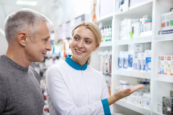 Amistosa Mujer Química Ayudando Cliente Masculino Senior Mostrando Surtido Farmacia — Foto de Stock