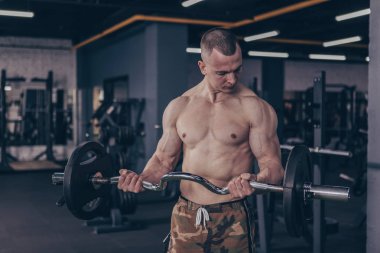 Ağır halter kaldırma spor salonunda, çalışma dışarı kas gömleksiz adam. Seksi stron gövdeli barbell ile pazı egzersizleri yapıyor atletik erkek sökük. Spor motivasyon, vücut geliştirme kavramı