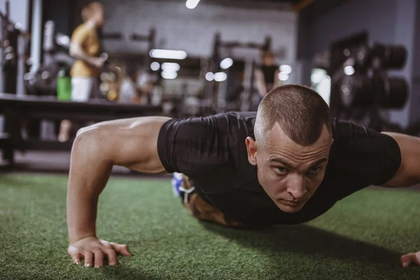 Şınav spor salonunda egzersiz kas güçlü bir genç adamın fotoğrafını kırpılmış. Kendine güvenen atletik erkek spor stüdyosu, kopya alanı çalışma dışarı. Sağlık, hobi, motivasyon kavramı
