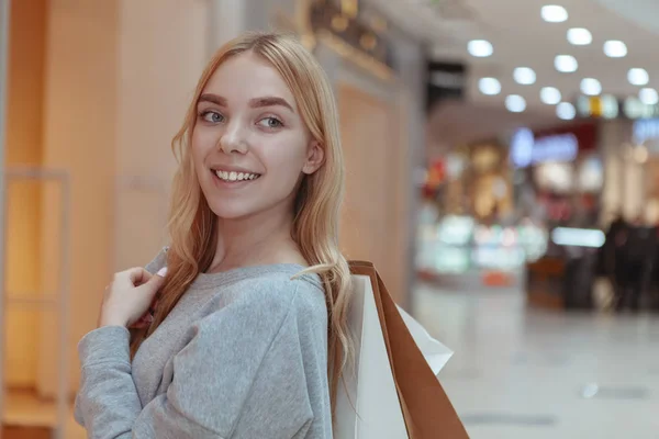 Linda jovem mulher fazendo compras no shopping local — Fotografia de Stock