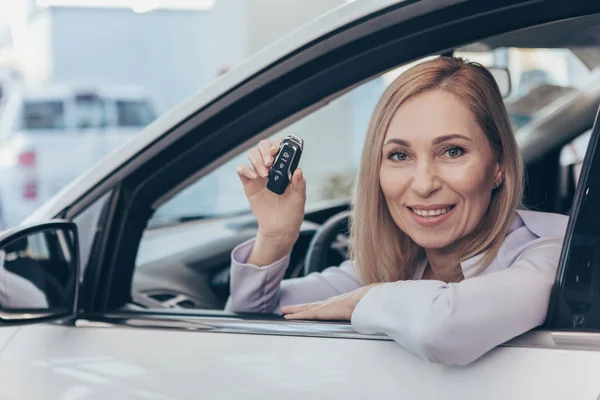 Mujer Madura Feliz Sentado Nuevo Automóvil Sonriendo Alegremente Cámara Sosteniendo — Foto de Stock