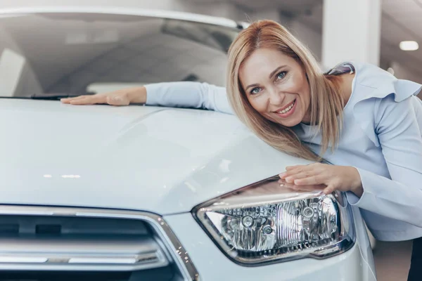 Счастливая Зрелая Женщина Обнимает Свой Новый Автомобиль После Покупает Салоне — стоковое фото