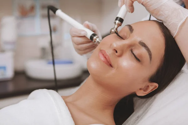 Adorável jovem mulher visitando cosmetologista na clínica de beleza — Fotografia de Stock