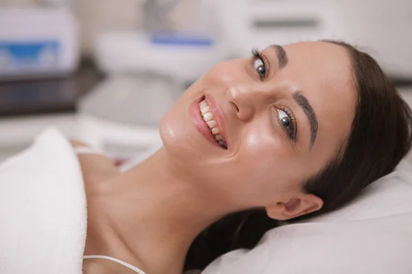 Милая молодая женщина, посещающая косметолога в клинике красоты — стоковое фото