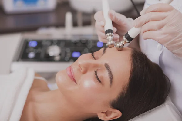 Adorável jovem mulher visitando cosmetologista na clínica de beleza — Fotografia de Stock