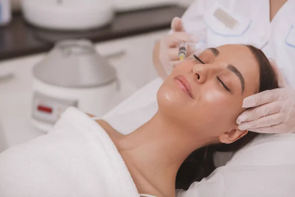 Lovely young woman visiting cosmetologist at beauty clinic — Stock Photo, Image