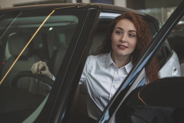 Preciosa mujer comprando coche nuevo en el concesionario — Foto de Stock