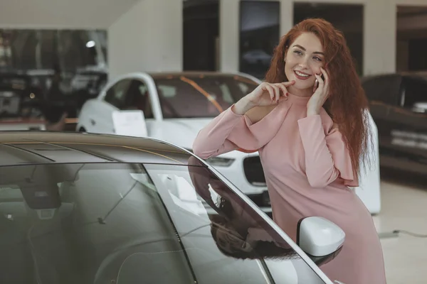 Bying yeni araba ise onun akıllı telefon kullanan çekici kadın — Stok fotoğraf