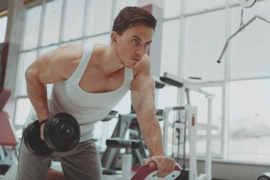 Gömleksiz adam salonunda dumbbells ile egzersiz sökük