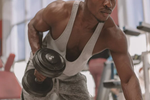 Atlético hombre africano haciendo ejercicio con pesas en el gimnasio — Foto de Stock