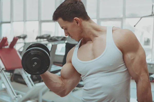 Hombre musculoso haciendo ejercicio en el gimnasio — Foto de Stock