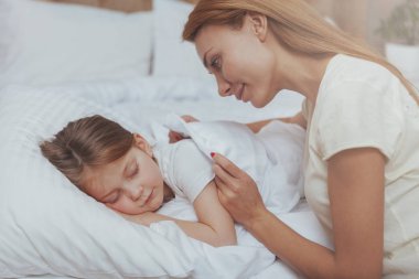 Kızı uykuda izlerken güzel kadın
