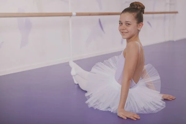 Charming young girl ballerina exercising at dance school