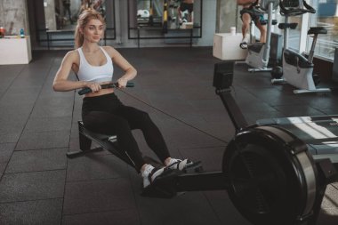 Beautiful young fitness woman working out at the gym