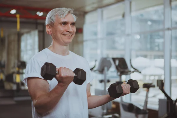 Hombre mayor haciendo ejercicio en el gimnasio — Foto de Stock