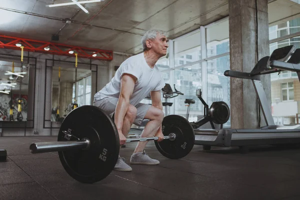 Hombre mayor haciendo ejercicio en el gimnasio — Foto de Stock