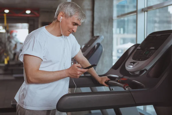 Hombre mayor haciendo ejercicio en el gimnasio — Foto de Stock