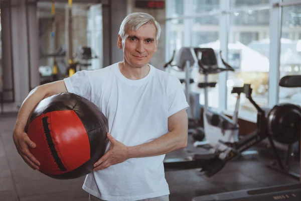 Hombre mayor haciendo ejercicio en el gimnasio — Foto de Stock