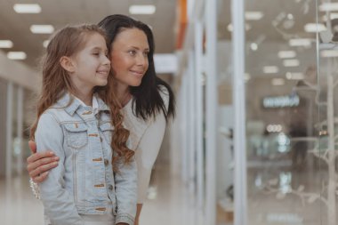 Cute little girl shopping at the mall with her mother